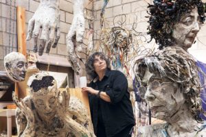 Mindy Alper stands amid some of her sculptures.